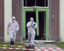 Forensic experts leave a Muslim school in Eindhoven, the Netherlands, where an explosion had blown of the door and shattered some windows.