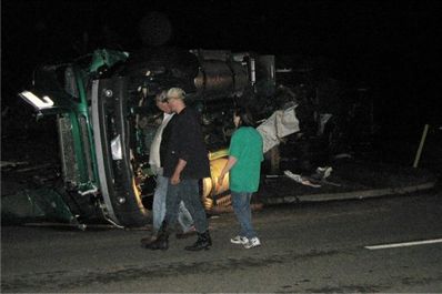 People walk past an overturned semi truck in Greensburg, Kan. early Saturday morning, May 5, 2007.