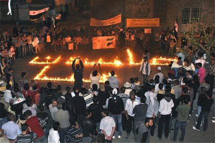 Syrians gather around Arabic writing made from fire on Thursday which reads, "we will continue" during a demonstration in Zabadani neighborhood, Damascus, Syria. The head of a U.N. observer team in Syria cautioned Friday that the mission cannot achieve a permanent end to the violence without genuine talks between the two sides that have been locked in a violent conflict for more than a year.