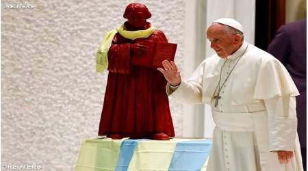 Francis stands with a statue of Martin Luther