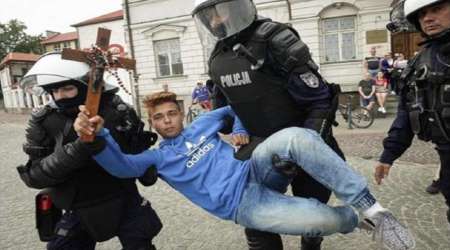 Lone boy holds crucifix high to protest LGBT march, police carry him away
