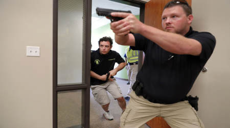 In this July 21, 2019 photo, Trainees Chris Graves, left, and Bryan Hetherington, right, participate in a security training session at Fellowship of the Parks campus in Haslet, Texas. An industry has sprung up following mass shootings at houses of worship around the country to train civilians to protect their churches with the techniques and equipment of law enforcement.