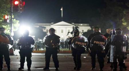 Police form a line on H Street as demonstrators gather to protest the death of George Floyd, Sunday, May 31, 2020, near the White House in Washington.