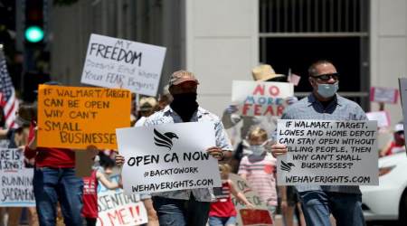 Activists hold signs and protest the California coronavirus lockdown on May 1, 2020 in San Diego, California.