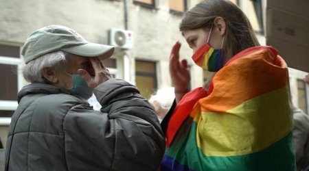 An elderly Polish woman makes the sign of the Cross with a young LGBT activist, April 29, 2021, Warsaw, Poland.