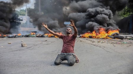 A man films himself in front of tires on fire during a general strike launched by several professional associations and companies to denounce insecurity in Port-au-Prince on October 18, 2021. A nationwide general strike emptied the streets of Haiti's capital Port-au-Prince on Monday with organizers denouncing the rapidly disintegrating security situation highlighted by the kidnapping of American and Canadian missionaries at the weekend. The kidnapping of 17 adults and children by one of Haiti's brazen criminal gangs underlined the country's troubles following the assassination of president Jovenel Mose in July and amid mounting lawlessness in the Western hemisphere's poorest nation